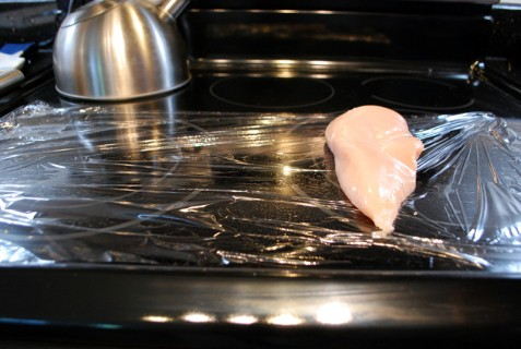 Place the chicken on plastic wrap Place the chicken on plastic wrap